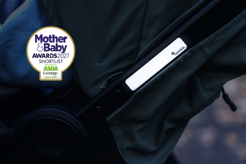 Close up of reflective stickers on pram in low light, with Mother & Baby Awards 2027 Shortlist bage in top left corner of image