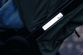 Close-up of a Twinkle Safe reflective pram sticker applied to a dark green pram frame